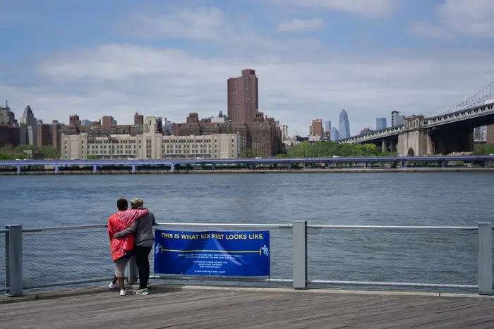 A photo of two people embracing at Brooklyn Bridge Park